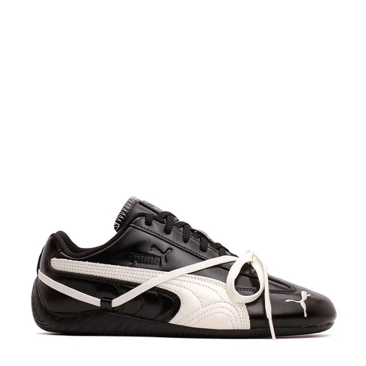 Black and white glossy Puma sneakers with white laces.