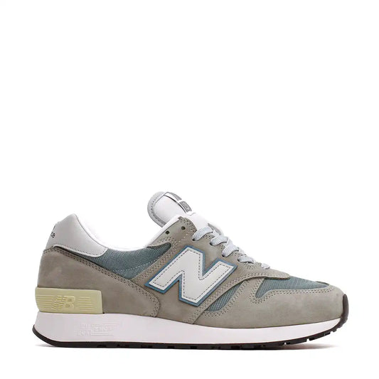 A gray and light blue New Balance sneaker with a white midsole and black outsole.