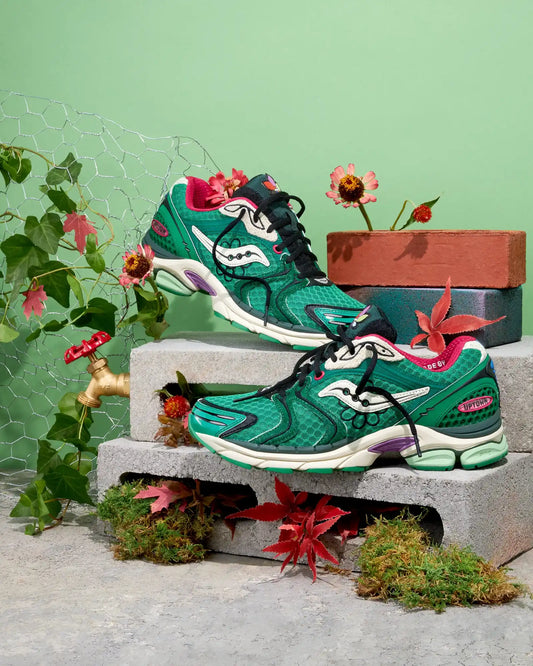 Green snake skin patterned saucony running shoe with white accents and pink laces.