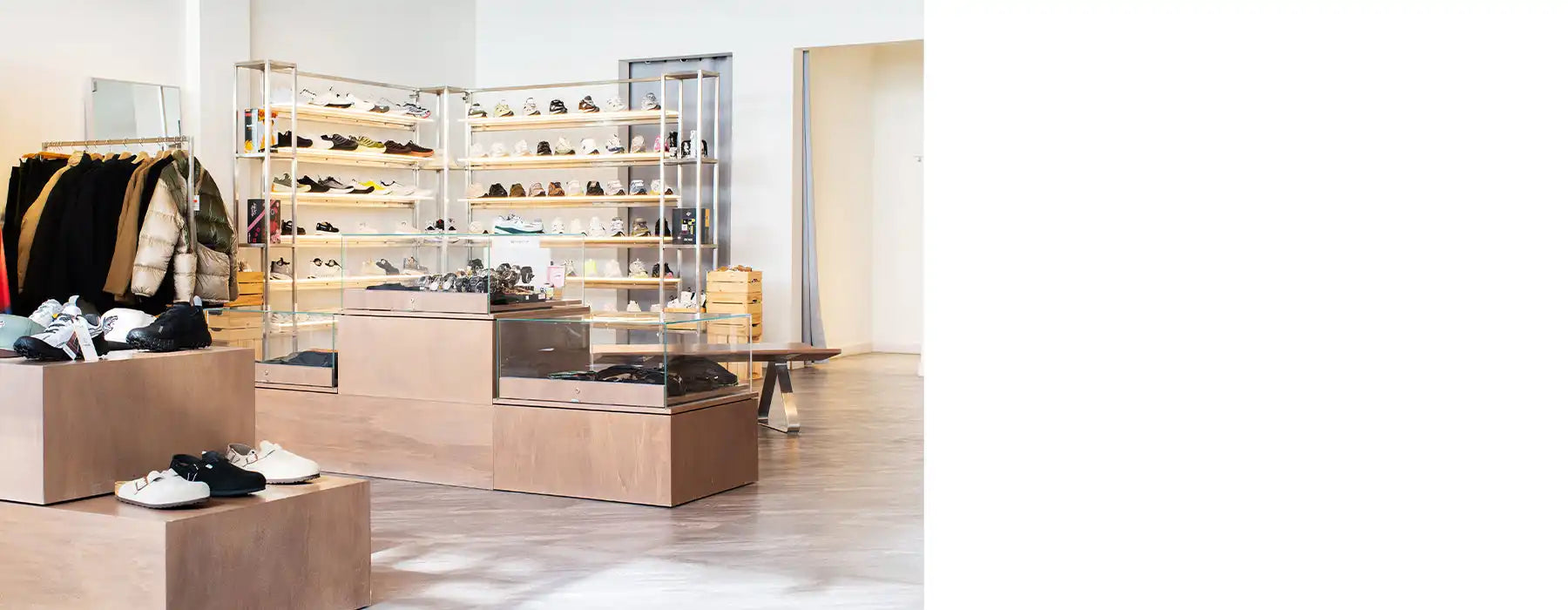 White and black sneaker display rack with clear acrylic shelves.